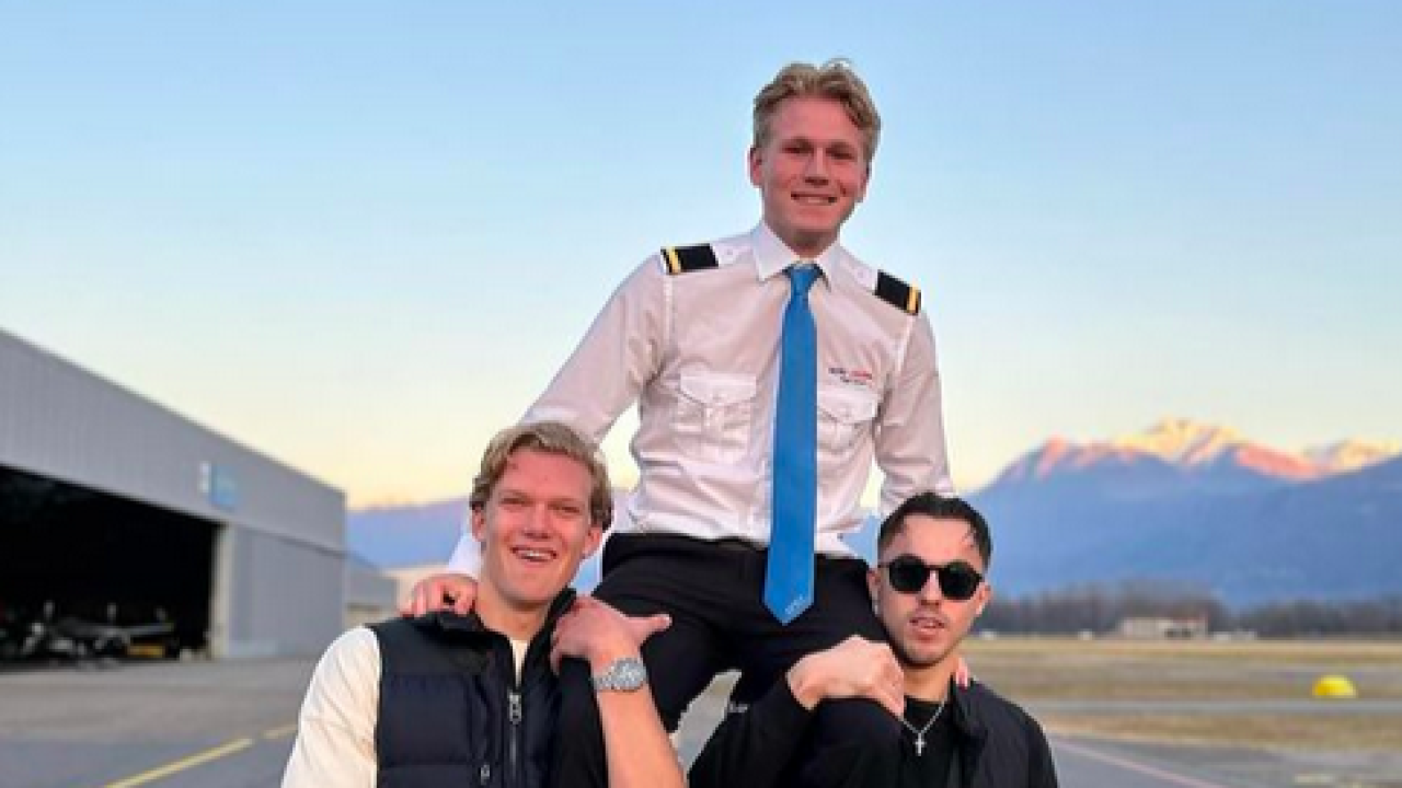 Student piloot op schouders van twee andere studenten